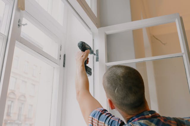 Person drilling a window into place 