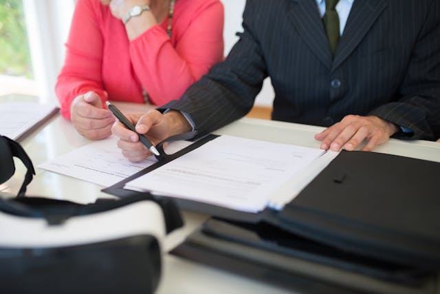 two people signing documents